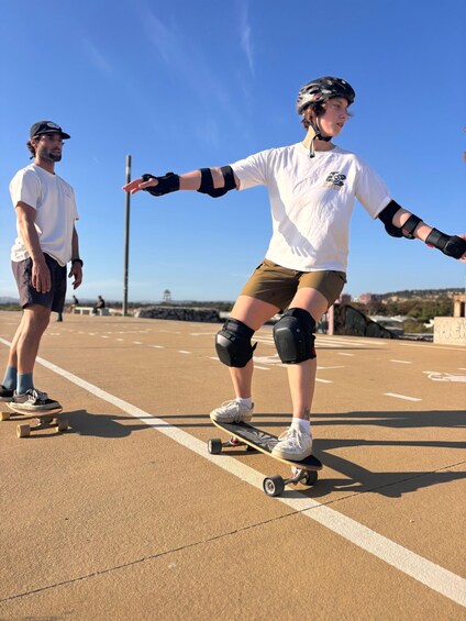 A person skateboarding on a smooth surface with a clear sky in the background. 1