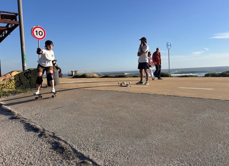 A coastal road with a speed limit sign, a pedestrian walkway, and a view of the ocean. 2