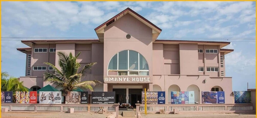 A building with a large arched entrance and the name 'OMANYE HOUSE' above it. 5