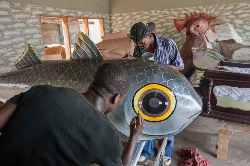 A person painting a fish sculpture. 1