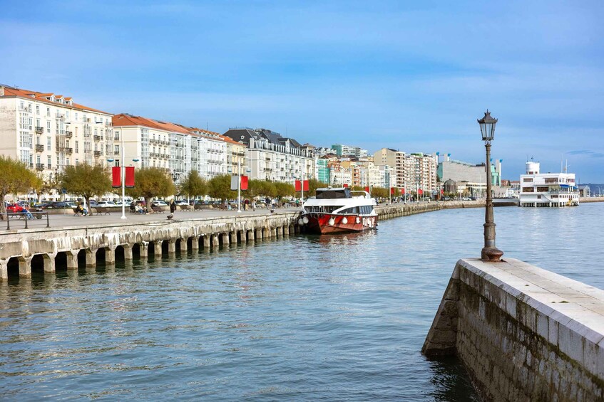 A river with a boat, a pier, and buildings along the riverbank. 3