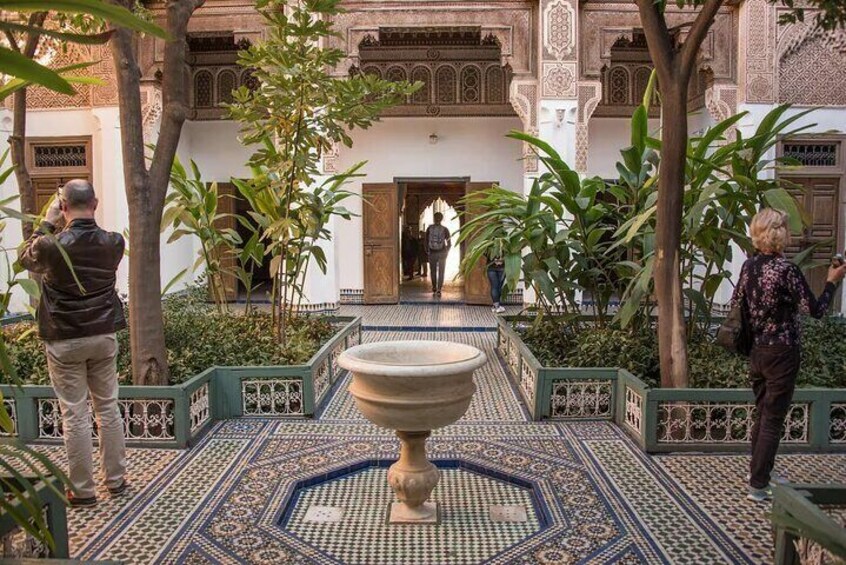 Ein Innenhof mit Springbrunnen, Fliesenboden und aufwendiger Architektur. 1
