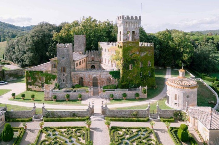 A castle with a tower, surrounded by manicured gardens and a circular building. 2