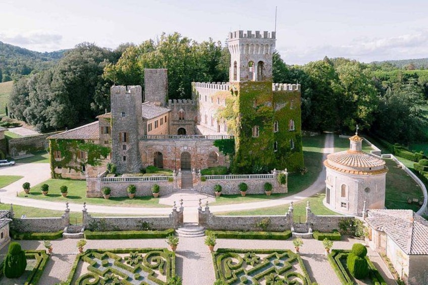 A castle with a tower, surrounded by manicured gardens and a circular building. 2