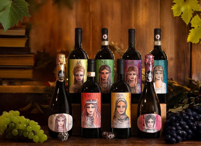 A collection of wine bottles with unique labels, arranged on a wooden surface with grapes and books in the background. 4