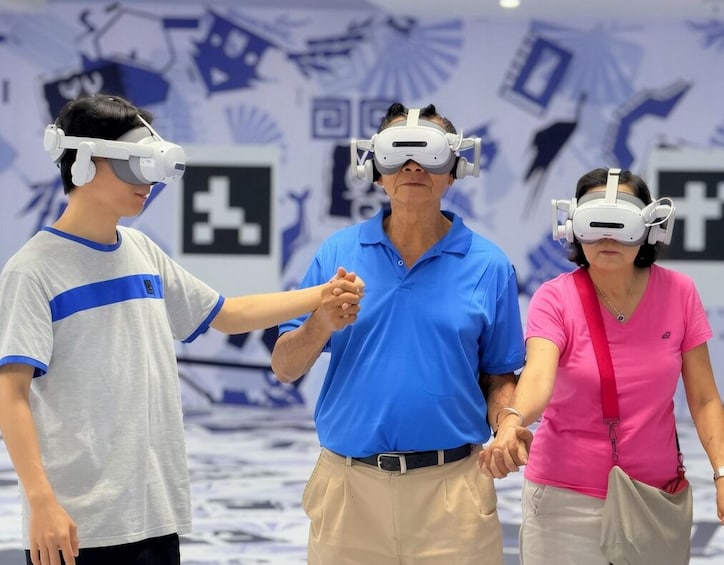 Three people wearing VR headsets in a room with a white floor and blue wall decorations. 5