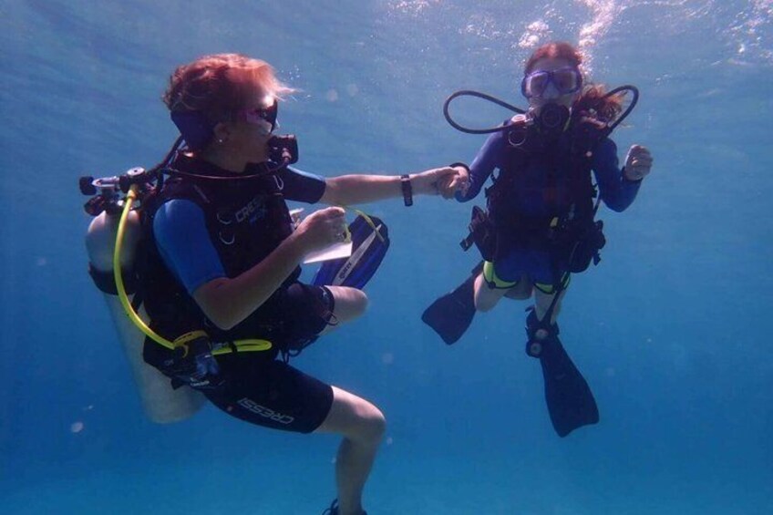 Two scuba divers underwater, equipped with fins and oxygen tanks. 5