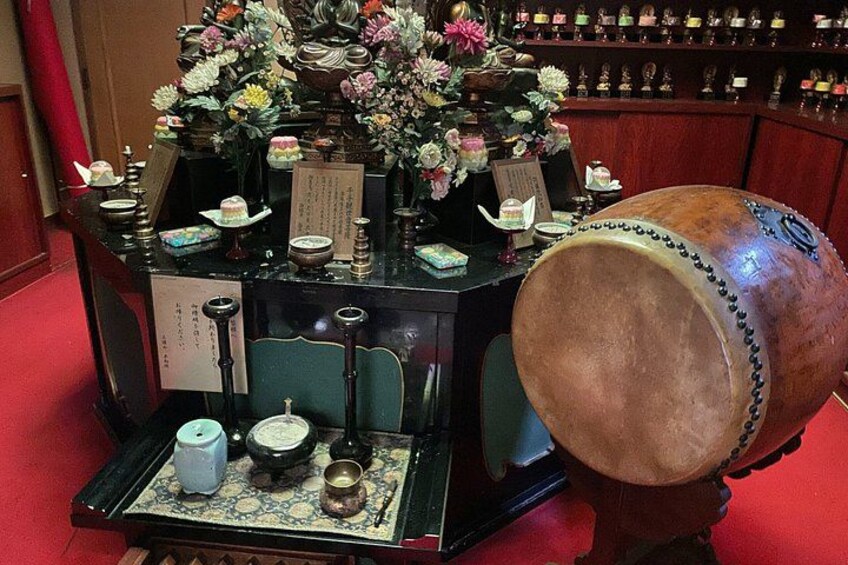 A traditional Japanese tea ceremony setup with a tea kettle, cups, and a decorative table. 2