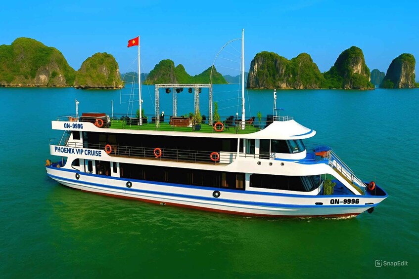 A cruise ship named 'Phoenix VIP Cruise' with the registration number 'ON-9996' sailing on a calm sea with greenish water and limestone islands in the background. 5