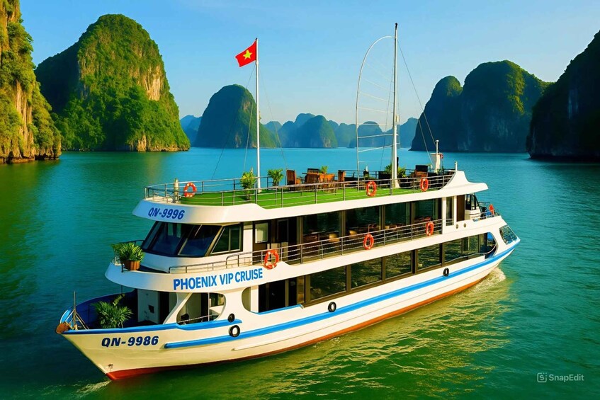 A white and blue boat named 'PHOENIX VIP CRUISE' with the registration number 'QN-9986' on a calm river surrounded by green cliffs. 4