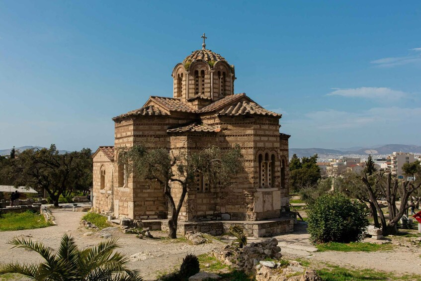 A stone church with a cross on top, surrounded by trees and a clear sky. 5