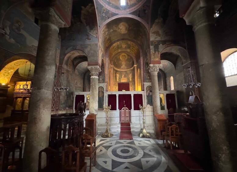 An interior of a church with high ceilings, ornate columns, and a central altar. 3
