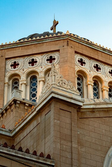 A building with ornate architectural details, including a cross on top and decorative arches. 1
