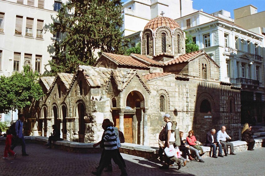 A historic church with a dome and arched windows, surrounded by modern buildings and pedestrians. 4