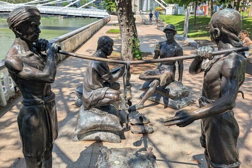 En bronzestatue af en mand med et gevær, en siddende mand med en skovl, og en stående mand med en skovl. 5