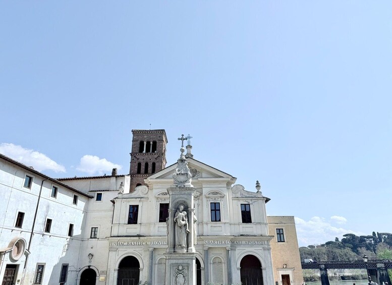A historic church with a bell tower and a statue of the Virgin Mary. 4