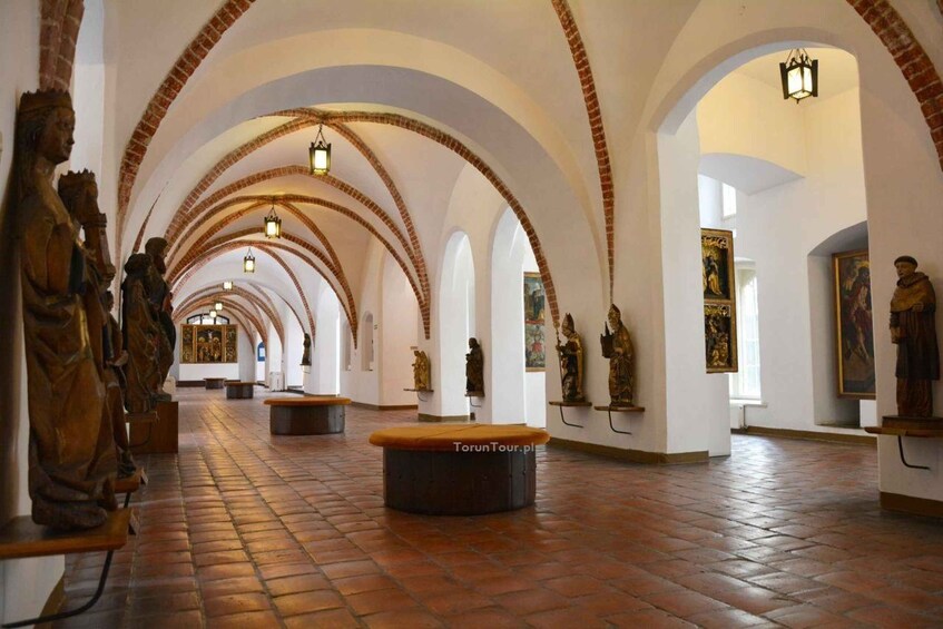 A cathedral interior with arched ceilings, statues, and artwork. 3