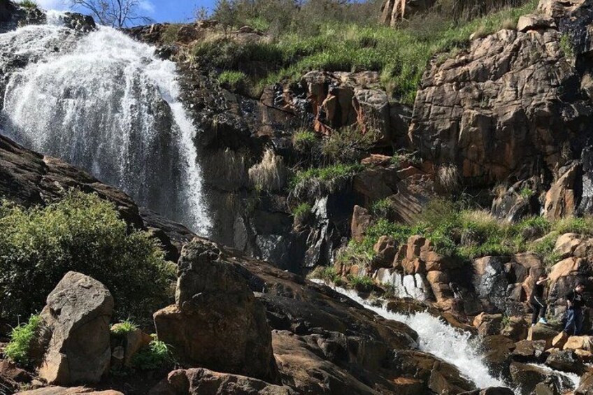Una cascada que se precipita sobre terreno rocoso, con abundante vegetación. 2