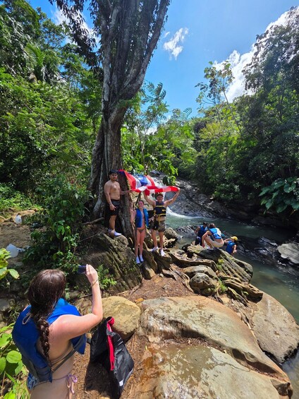 People hiking near a river in a forested area. 2
