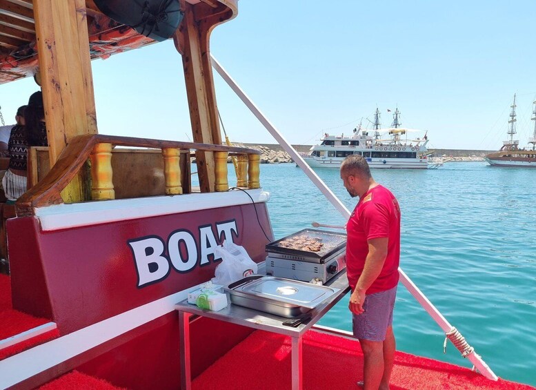 A man grilling on a boat with a grill labeled 'BOAT' and a red carpet. 2
