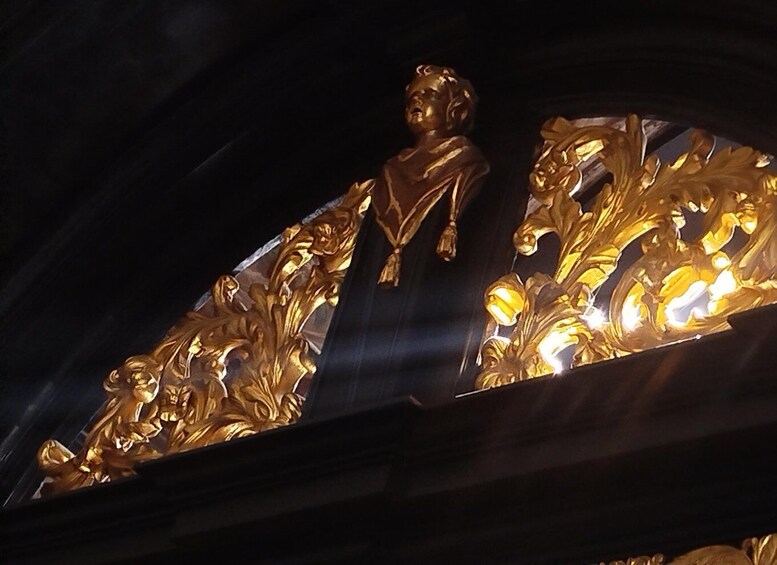 A golden statue of a figure with a horse, set against a dark background. 4