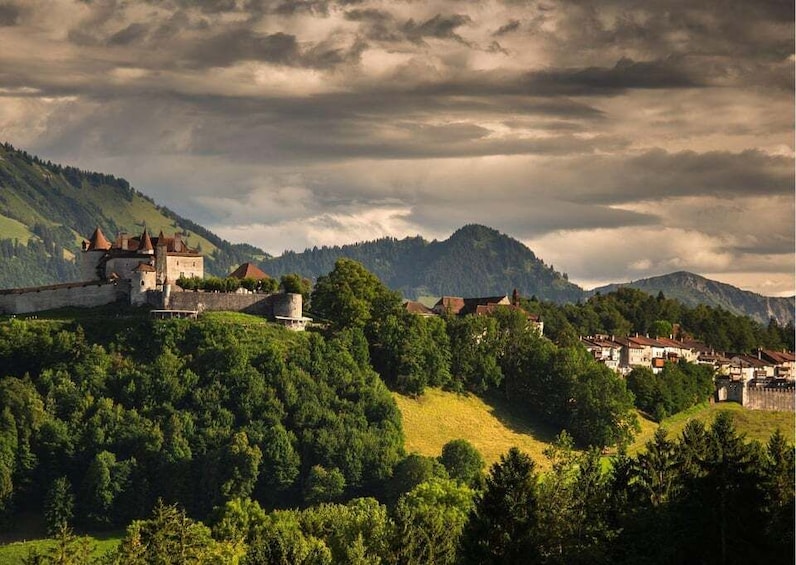 A castle on a hill, surrounded by lush greenery and mountains. 3