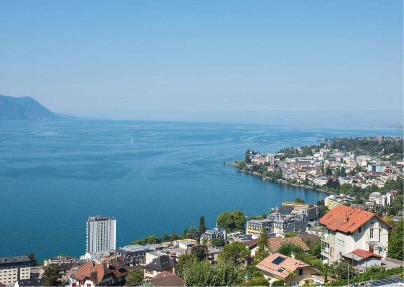 A coastal cityscape with a large body of water, a mountain in the background, and residential buildings. 2