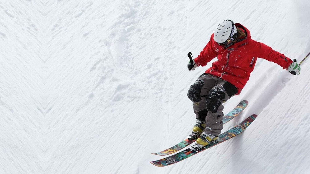 A skier in mid-air performing a jump on a snowy slope. 3