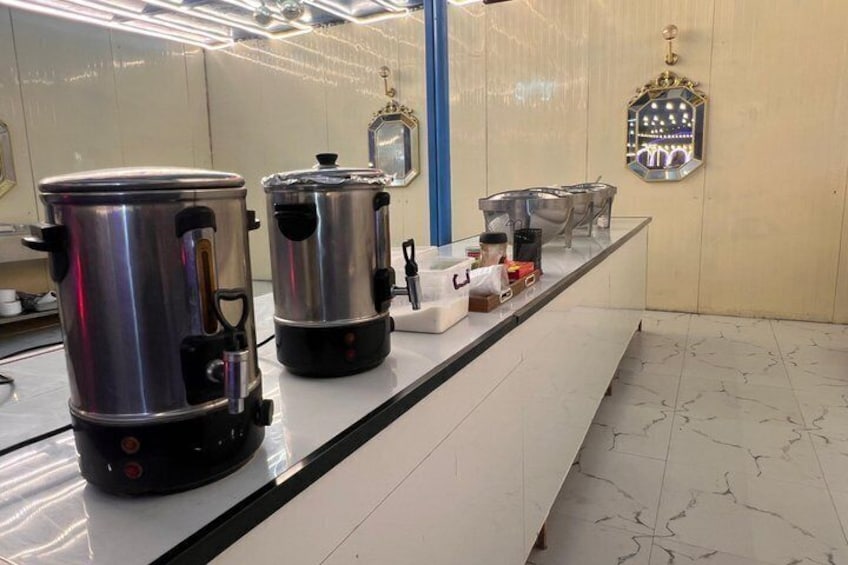 A kitchen counter with stainless steel pots and a coffee machine. 3