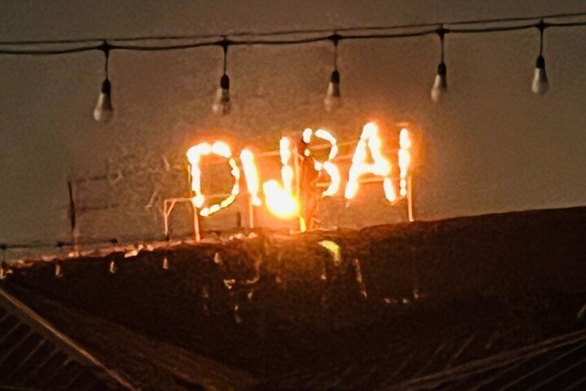 Illuminated letters spelling 'DUBAI' on a wall. 5
