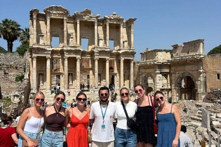 A group of people standing in front of the ancient ruins of the Library of Celsus in Ephesus. 3