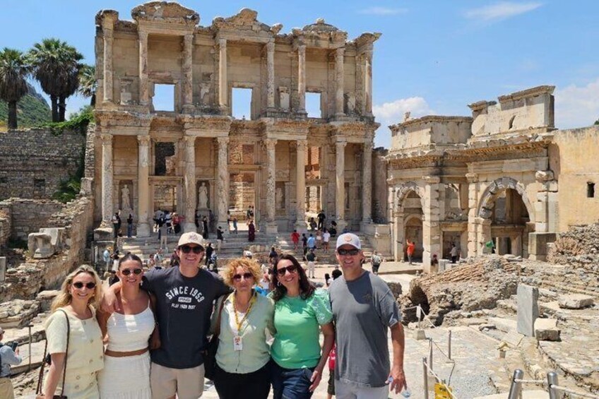 A group of people standing in front of ancient ruins with columns and arches. 5