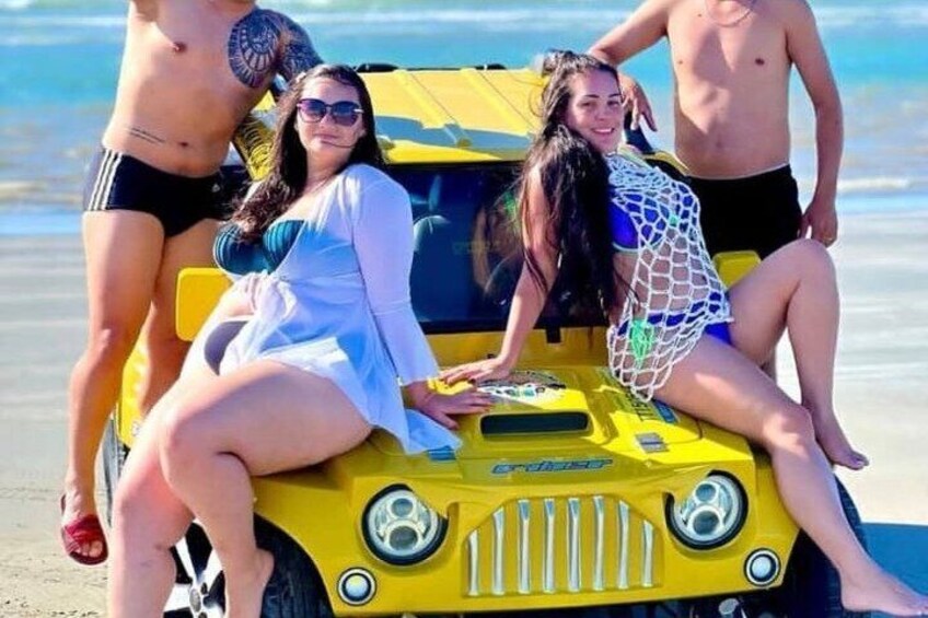 A group of people on a yellow vehicle at the beach. 5