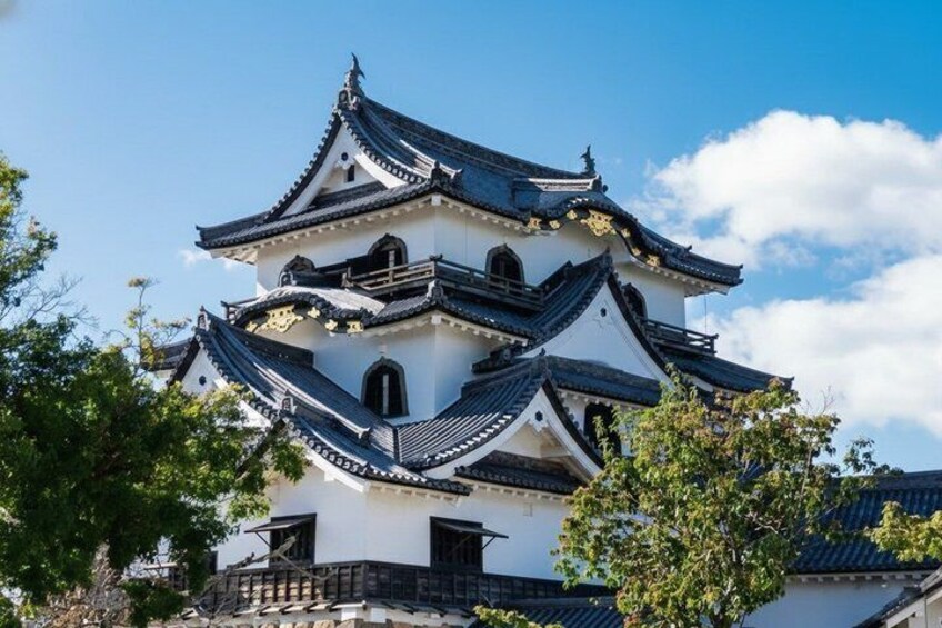 A traditional Japanese castle with multiple tiers and black tiled roofs. 1