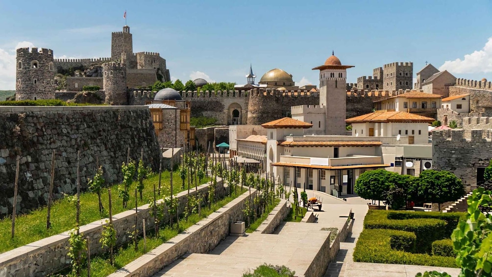 A historic fortified city with stone walls, towers, and domed buildings. 3