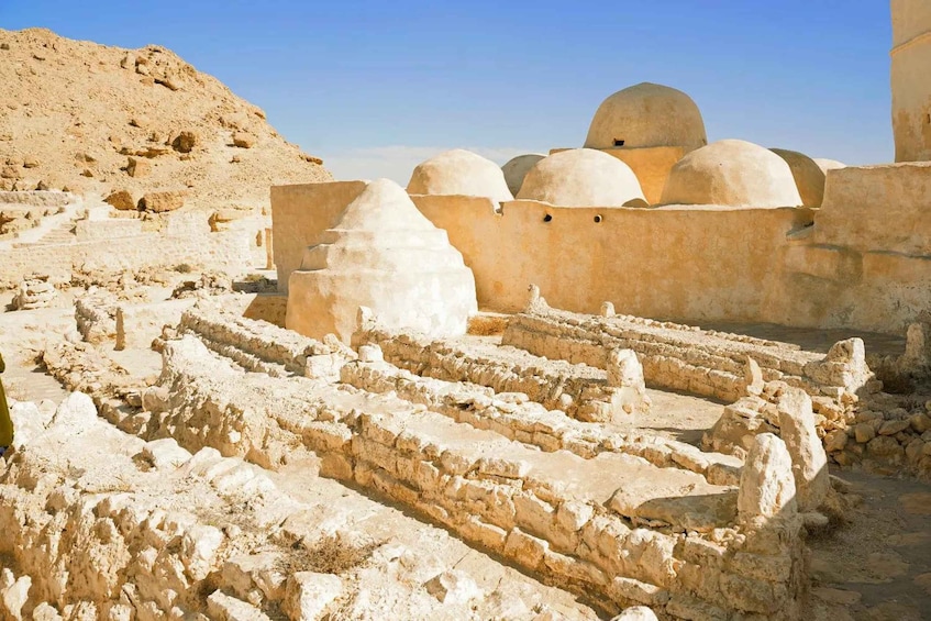 Ancient ruins with stepped structures and domed buildings. 4
