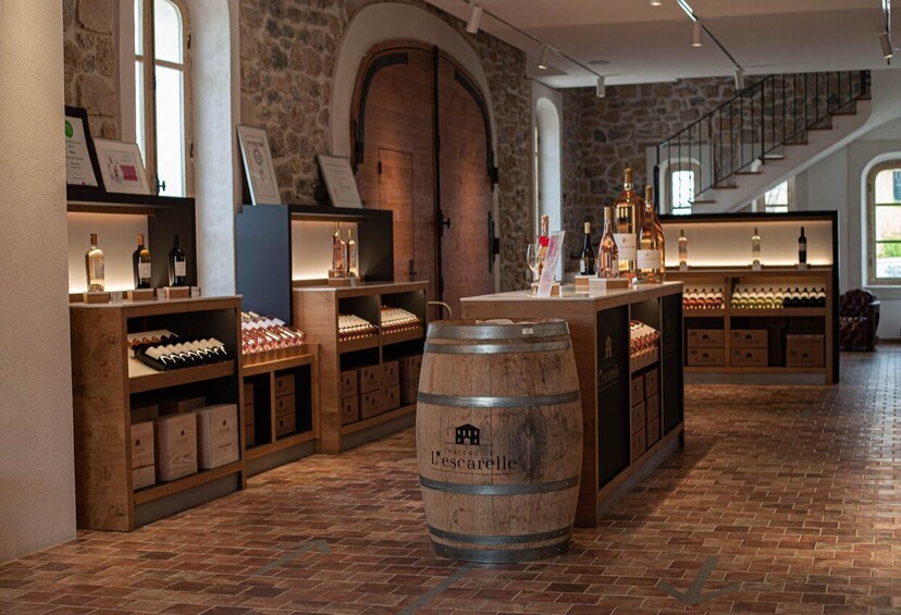 A wine cellar with wooden shelves and barrels, stone walls, and a staircase. 4