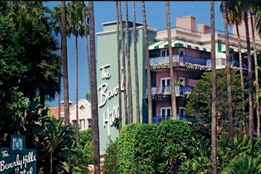 The Beverly Hills Hotel with palm trees and a clear sky. 2