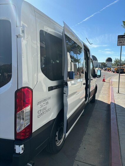 A white van parked on a street with a sign indicating 'RIGHT LANE BUSES ONLY 24 HOURS.' 4