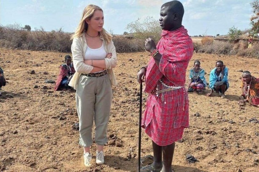 Une personne vêtue d’un costume traditionnel, debout dans un paysage aride et dégagé, où la végétation est rare. 4