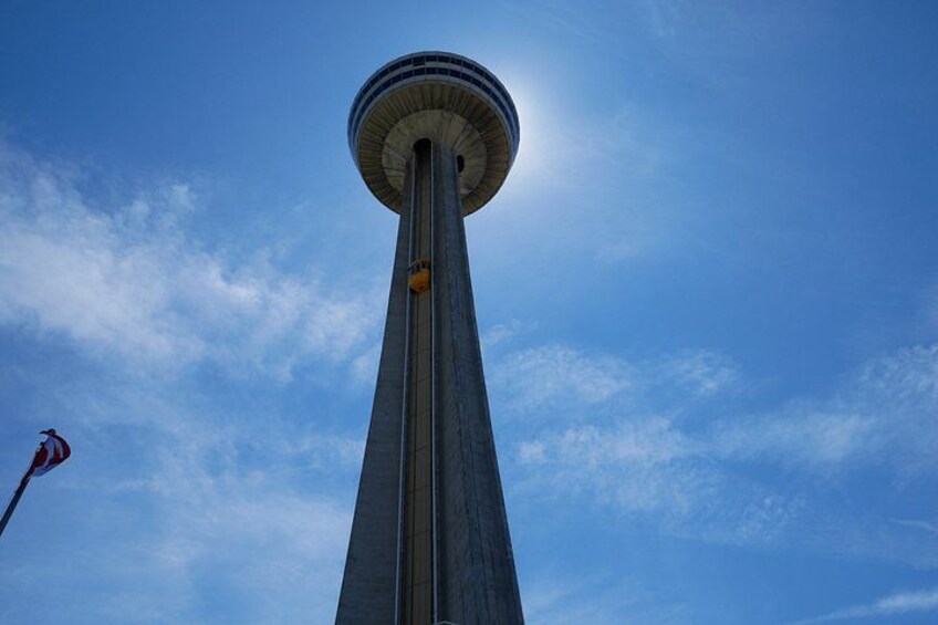 A tall tower with a circular observation deck against a blue sky. 4