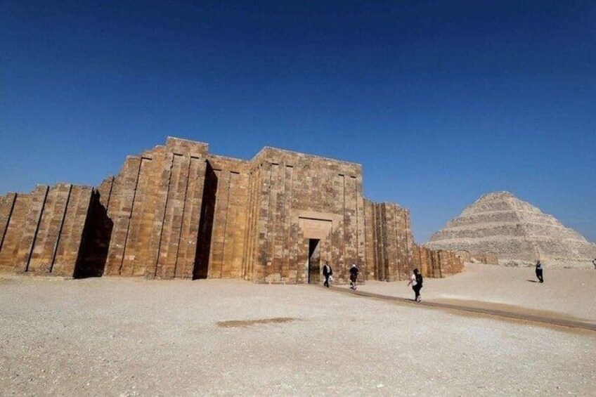 Et stort, gammelt tempelkompleks med en pyramide i baggrunden. 5