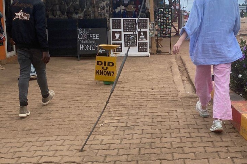 Een pad van bakstenen, een geel bord met de tekst 'WIST JE DAT?' en een coffeeshop op de achtergrond. 4