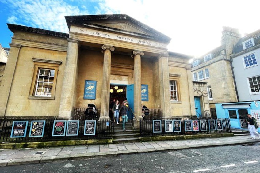 A historic building with columns, a blue door, and a sign for 'Friends Meeting House'. 2
