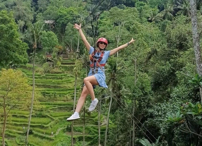 A person bungee jumping from a high wire in a lush, green landscape. 1