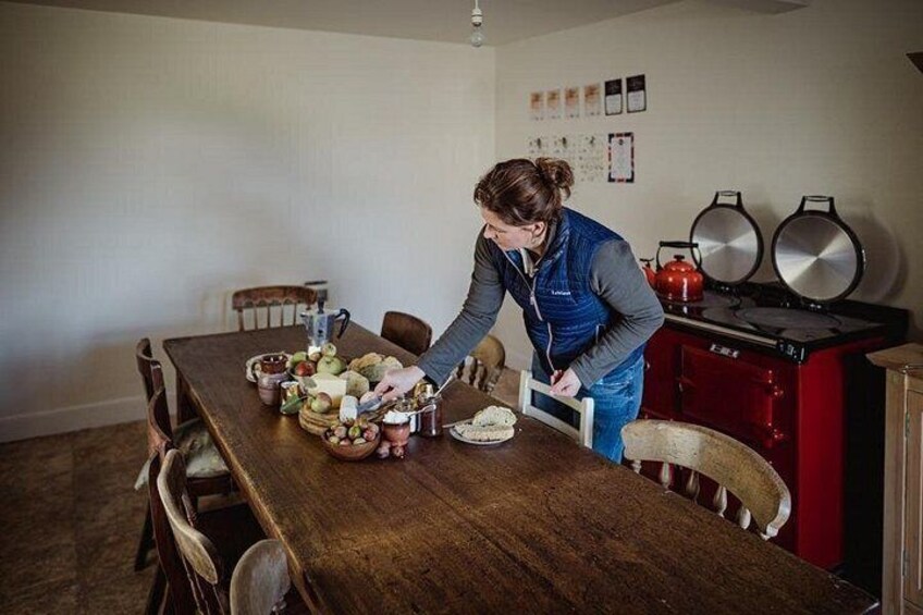 A person preparing food at a wooden table with various ingredients and kitchen utensils. 3