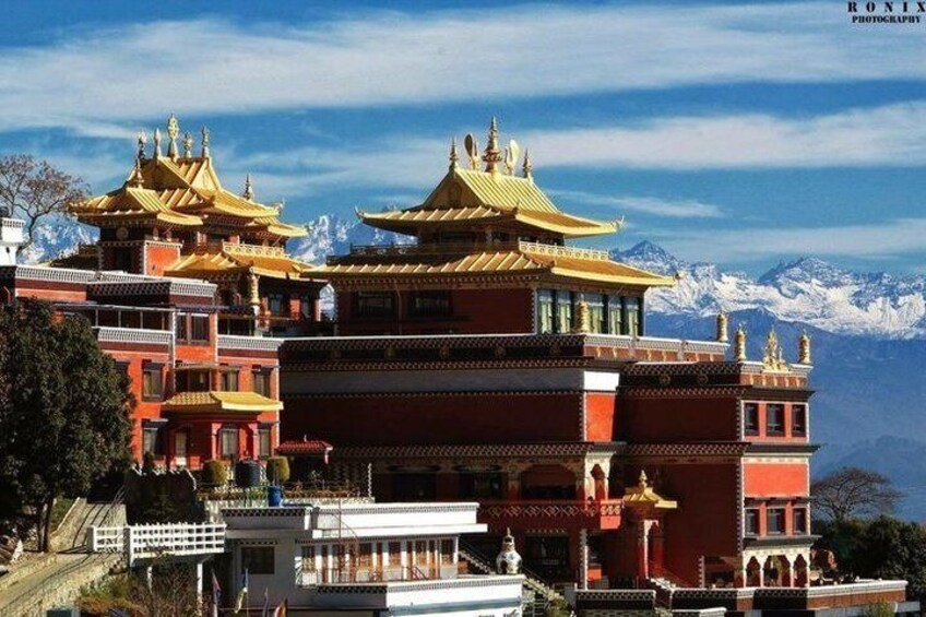 A multi-tiered temple with golden roofs, set against a backdrop of snow-capped mountains. 3