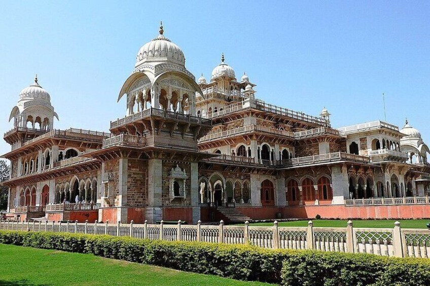 A large, ornate building with domes and arches, surrounded by a well-maintained lawn. 3