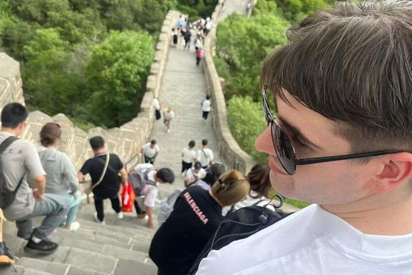 Una persona scende una scala in pietra, sullo sfondo una folla di turisti. 4