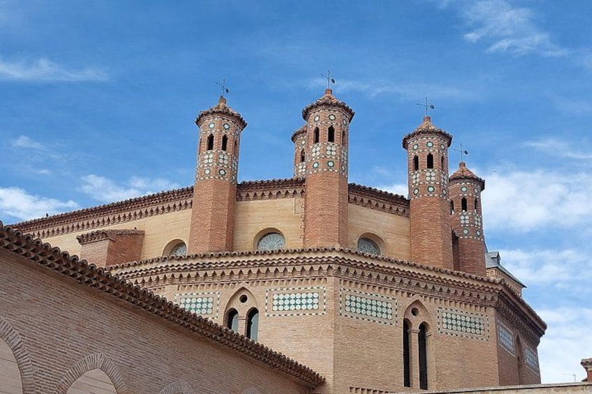 A historic building with three towers and a tiled roof. 2